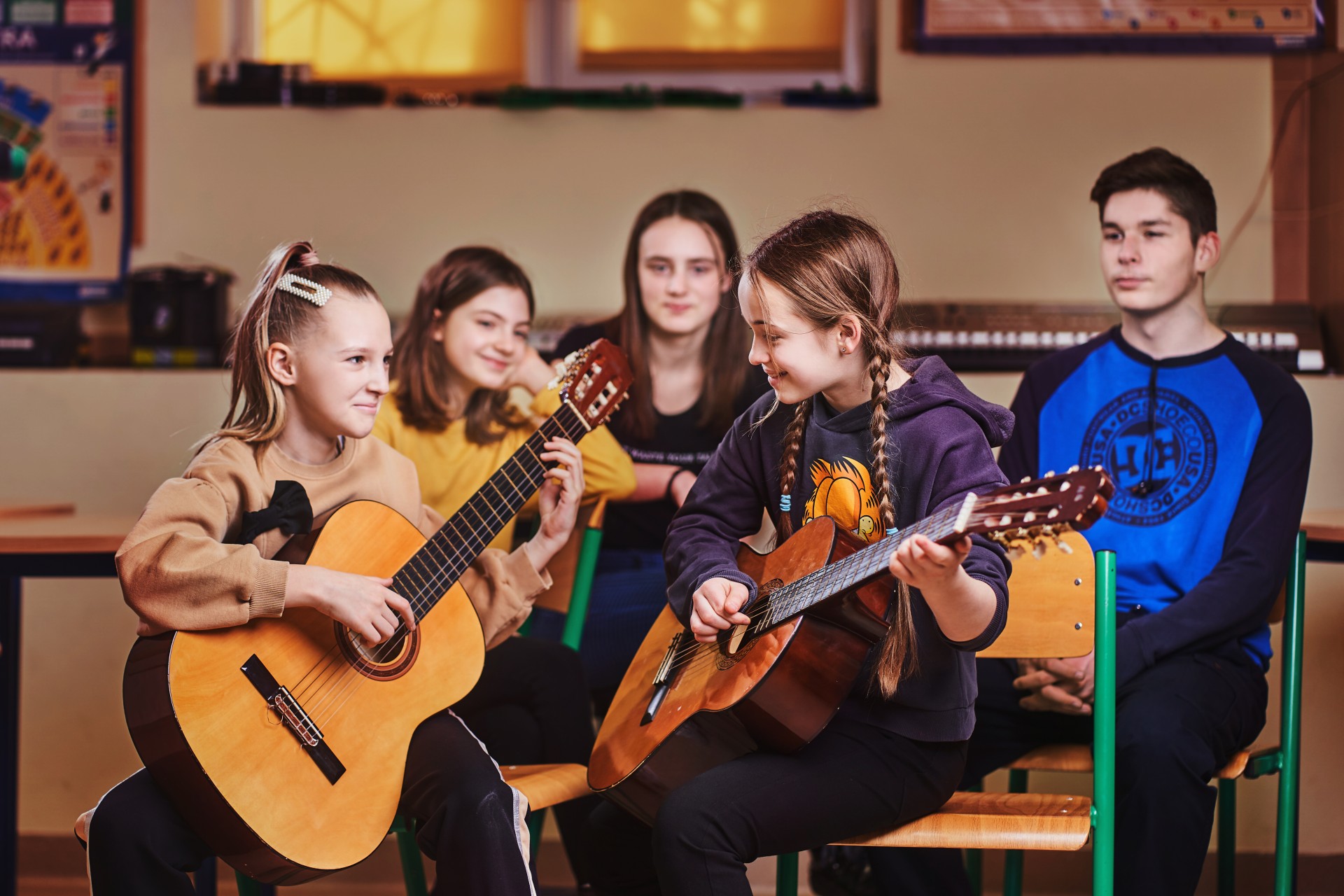 Uczniowie grający na gitarach podczas lekcji muzyki